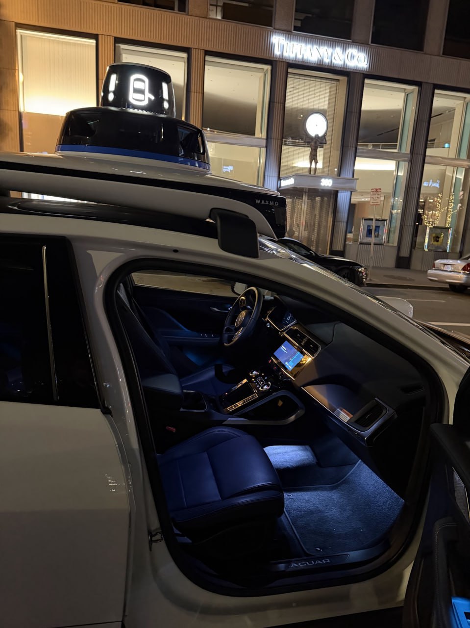 Waymo with door open on an empty San Francisco street